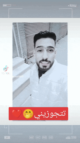 a black and white photo of a man with arabic writing on the bottom right corner