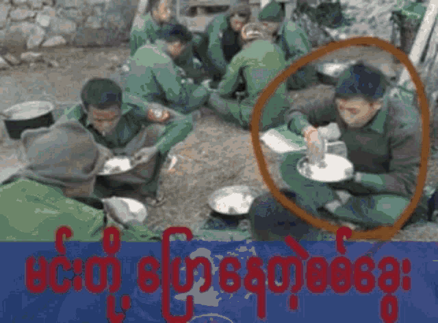 a group of soldiers are sitting around a table with plates of food