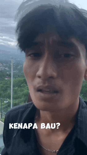 a man in a black shirt has the word kenapa bau on his face