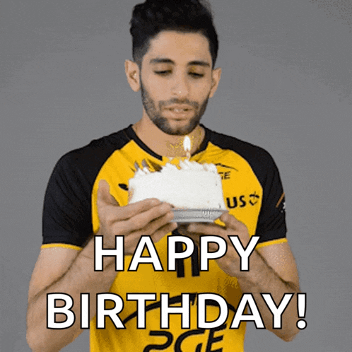 a man in a yellow shirt is holding a birthday cake with a candle lit up and the words happy birthday below him