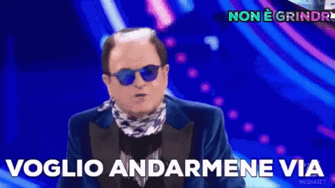 a man in a suit and sunglasses says " voglio andarmene via "