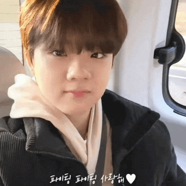 a young boy wearing a black jacket and a white hoodie looks at the camera .