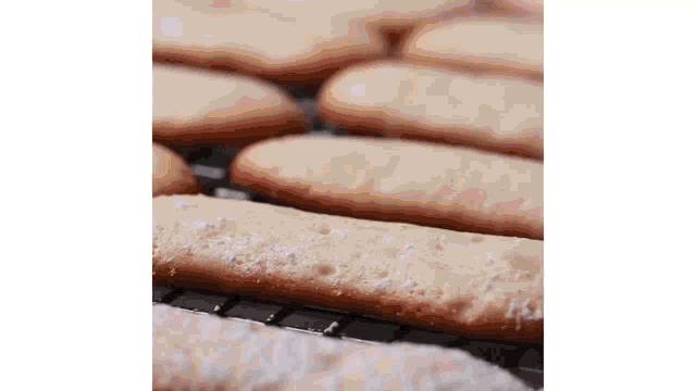 a bunch of cookies sitting on top of a cooling rack covered in powdered sugar .