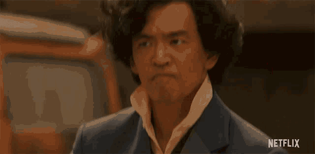 a man in a suit is making a funny face in a netflix advertisement .