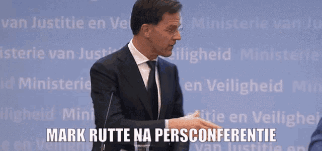 a man in a suit shakes hands with another man in front of a sign that says mark rutte na persoonentie