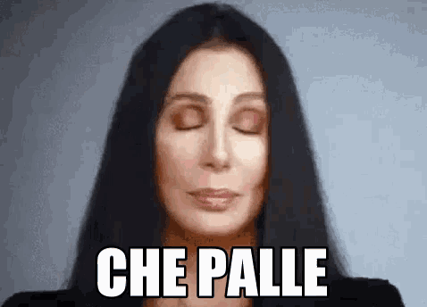 a close up of a woman with her eyes closed and the words che palle written on her face .