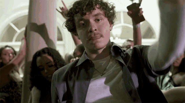 a man with a moustache is dancing in a crowd of people