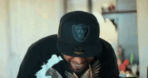 a man wearing a raiders hat and a black shirt