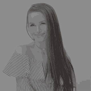 a black and white photo of a woman with long hair wearing a striped off the shoulder top and a choker .