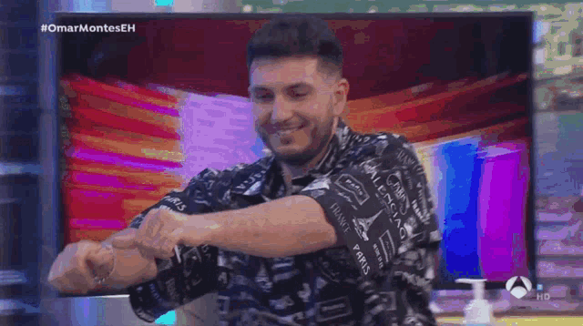 a man in a plaid shirt is dancing in front of a screen that says #omarmonteseh