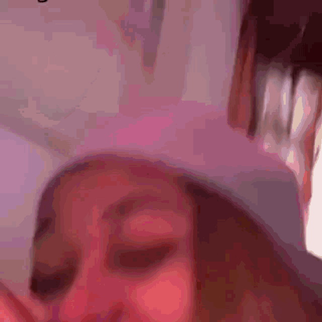 a close up of a person 's face with a pink hat on