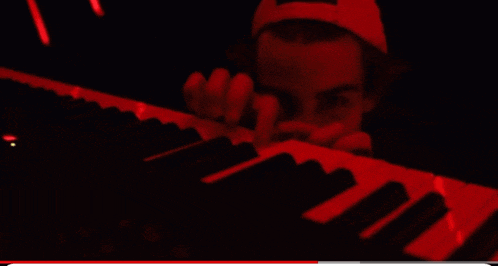 a close up of a person playing a keyboard in red light