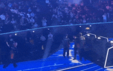 a man in a red shirt is standing on a stage in front of a crowd ..