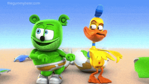 a green gummy bear and a yellow duck are on the beach