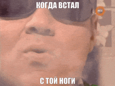a close up of a man wearing sunglasses with a foreign language caption