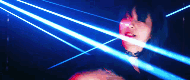a woman in a choker is surrounded by blue laser lights