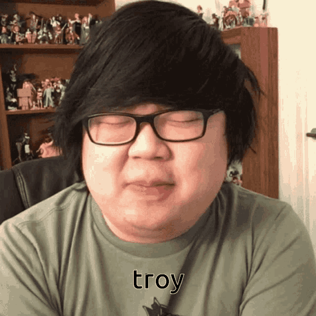 a man with glasses and a shirt that says troy on it