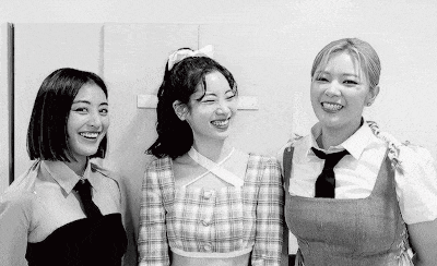three women are standing next to each other and smiling .