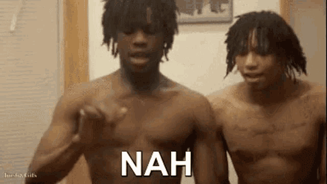 two shirtless men are standing next to each other in a room with the word nah written on the screen .