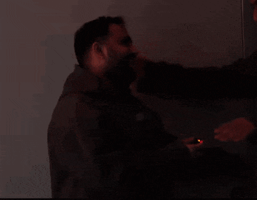a man with a beard is being punched in the face by another man .