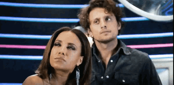 a man and a woman are standing next to each other and looking at something