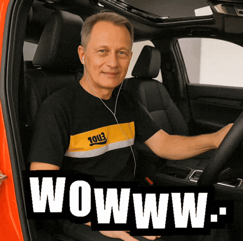 a man wearing headphones is sitting in the driver 's seat of a car with the words wowwww.com below him