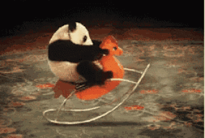 a panda bear riding a rocking horse on a rug