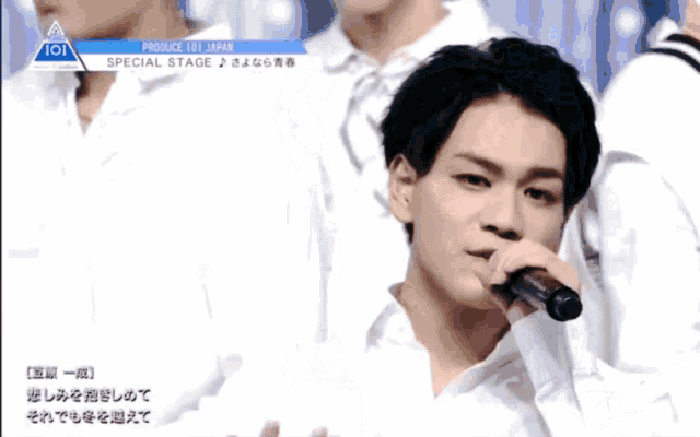 a man singing into a microphone with the word produce 101 japan on the bottom right