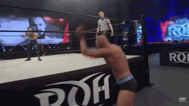 a man in a wrestling ring with the word roh on the wall