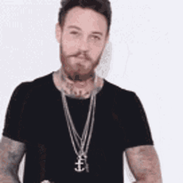 a man with a beard wearing a black shirt and a necklace