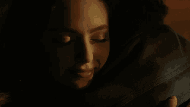 a close up of a woman 's face with a dark background