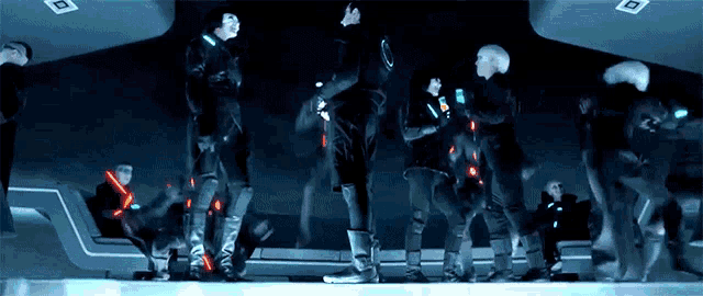 a group of people standing in a dark room with glowing lights