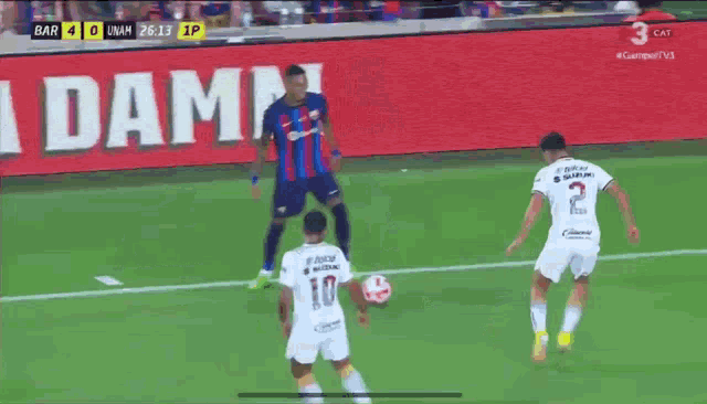 a soccer game is being played in front of a large la damm sign