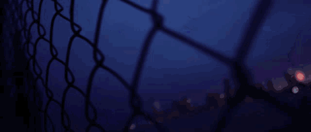 a blurry picture of a chain link fence with a red white and blue glitch