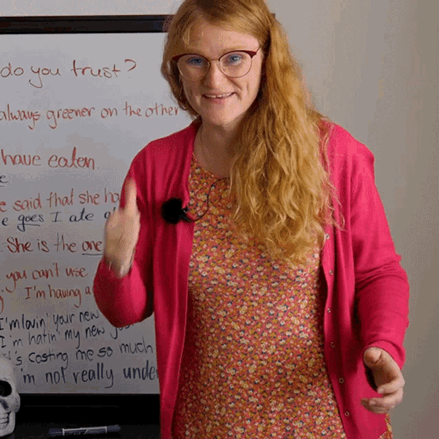 a woman stands in front of a white board that says " do you trust "