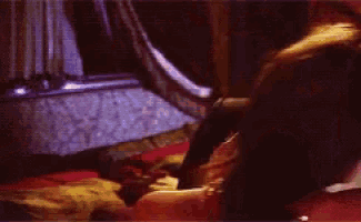 a man and a woman are kissing in a dark room