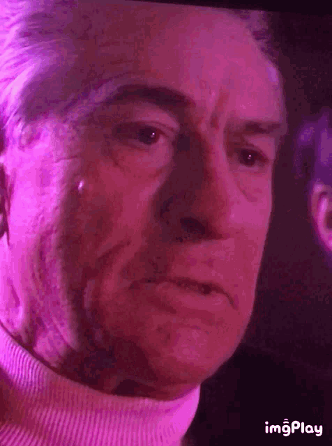 a close up of a man 's face with a pink background and the words imgplay at the bottom