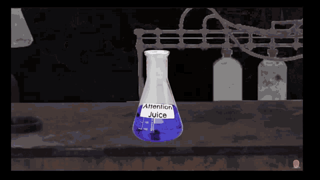 a beaker labeled attention juice is on a table