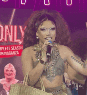 a woman is singing into a microphone in front of a sign that says " only "