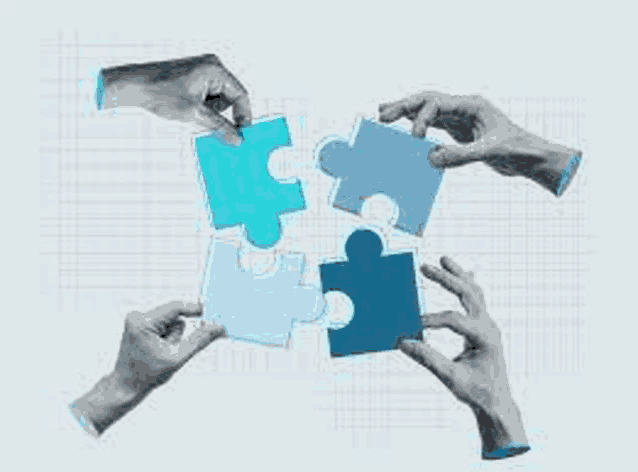 a group of people are holding puzzle pieces in their hands and putting them together .