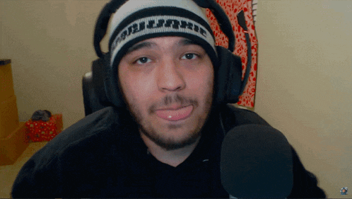 a man wearing headphones and a beanie that says ' uc ' on it