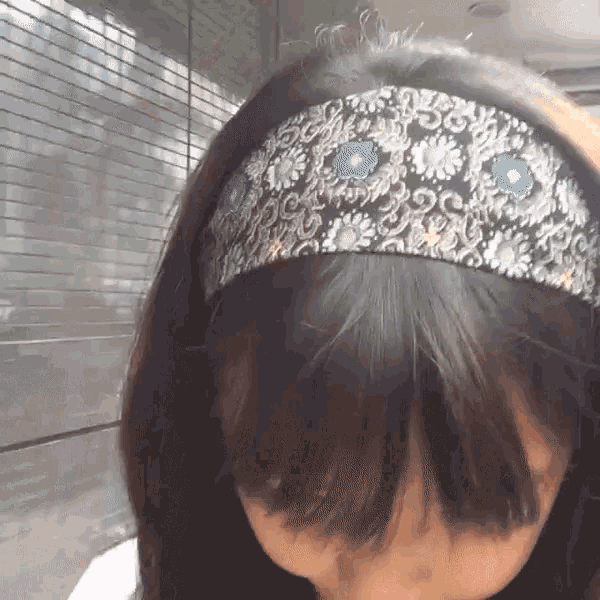 a woman wearing a headband with blue and white flowers