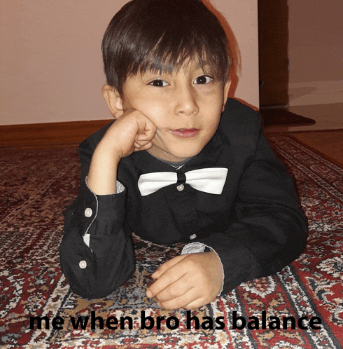 a young boy in a bow tie is laying on a rug with the caption me when bro has balance