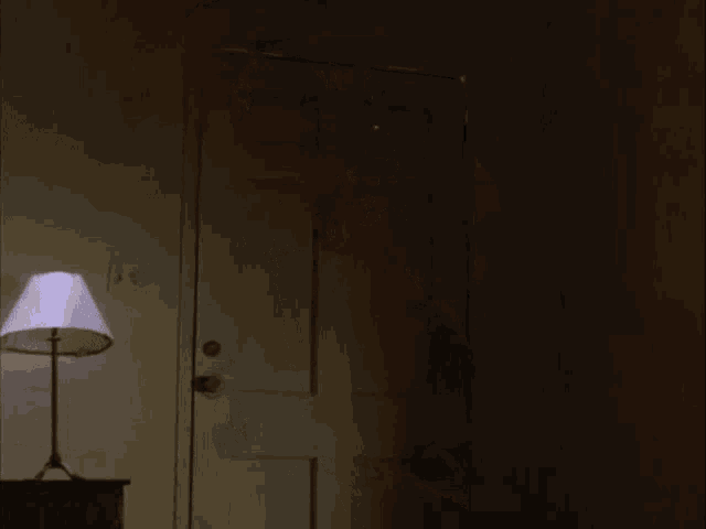 a shark is coming out of the door in a dark room .