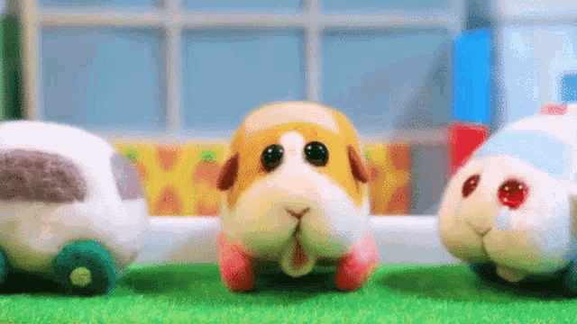 a group of stuffed animals are standing next to each other on a lush green field .