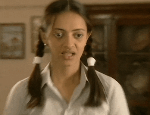 a woman with pigtails is making a funny face and sticking her tongue out