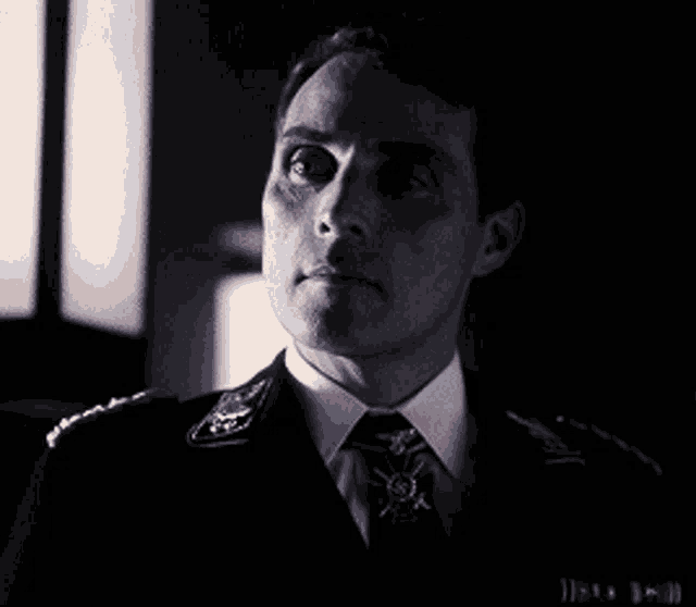 a man in a suit and tie with a cross on his necktie