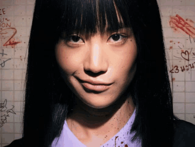 a close up of a woman 's face with graffiti on the wall behind her that says ee