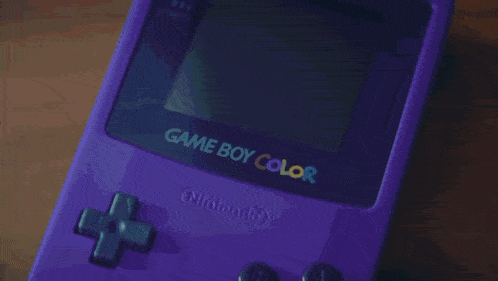a purple game boy is being held by a person