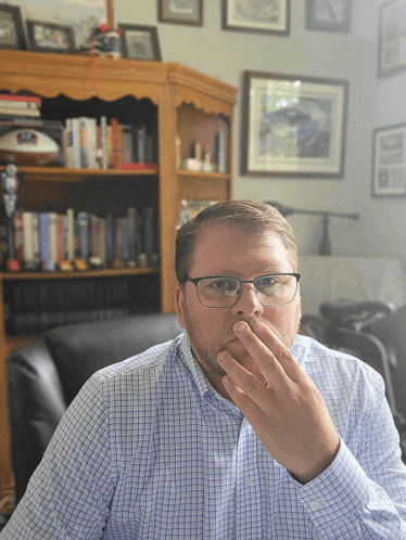 a man covering his mouth with his hand in a living room